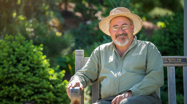 Panayoti Kelaidis sitting on bench smiling