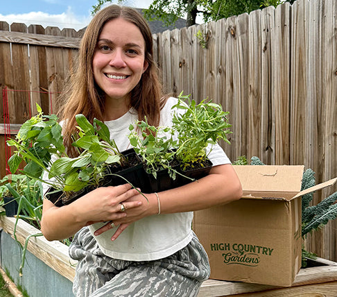 woman holding a high country gardens plant delivery in garden